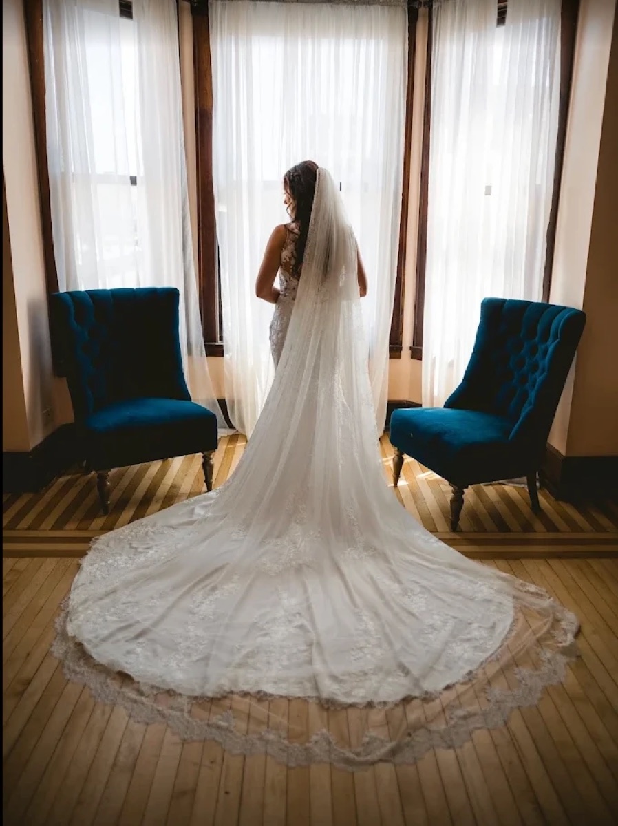 Bride in a lace-trained wedding gown altered by AZ Tailoring