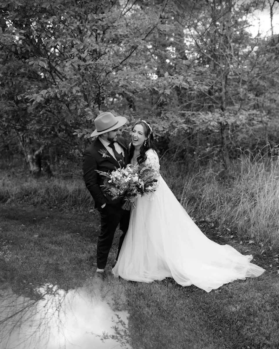 Bride and groom laughing together outdoors