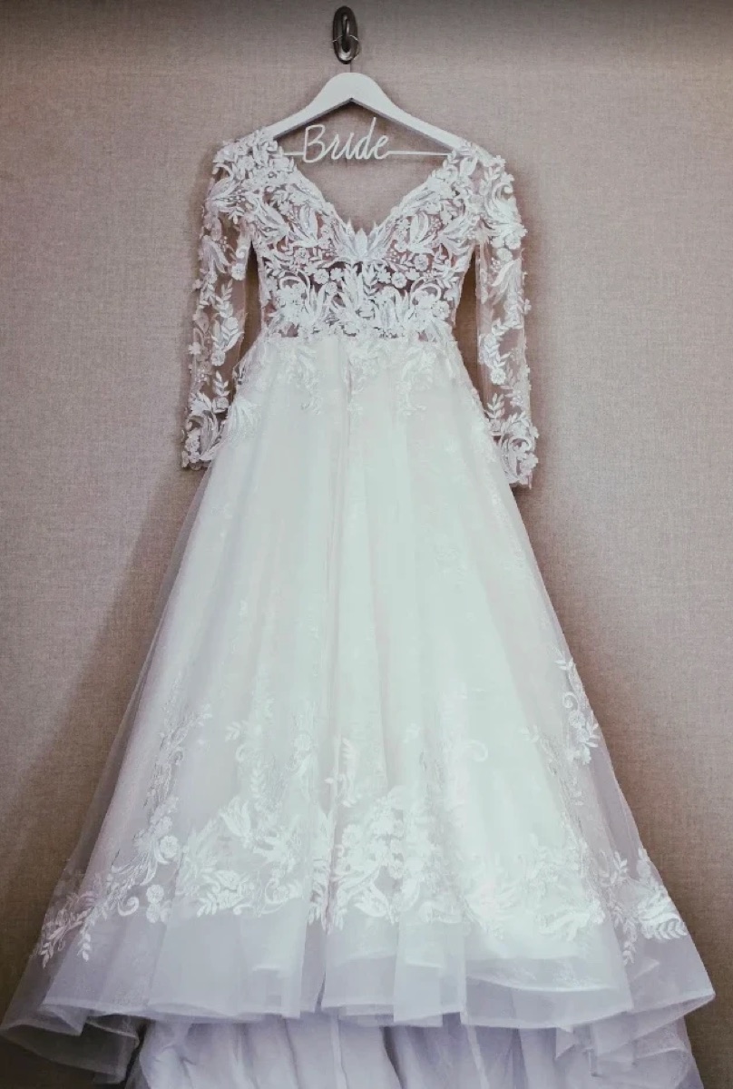 Lace wedding gown with long sleeves on a Bride hanger